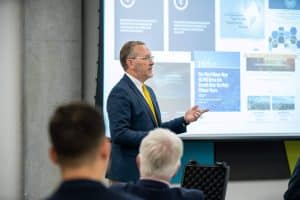 SpectrumX Center Director Nick Laneman is shown giving a presentation during Admiral Christopher W. Grady's visit.