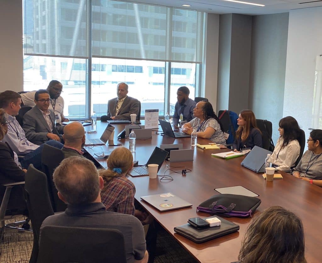 An image of a conference room with SpectrumX affiliated faculty, researchers, and students discussing projects.