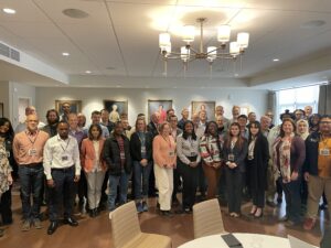 A group of SpectrumX Fall 2023 center meeting attendees smiles in a group photo.